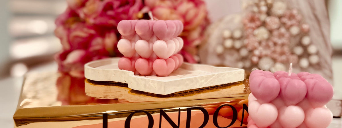 Pink heart-shaped bubble candles styled on a marble tray with floral accents, showcasing a romantic luxury candle gift idea for Valentine’s Day by Dahil Bar.