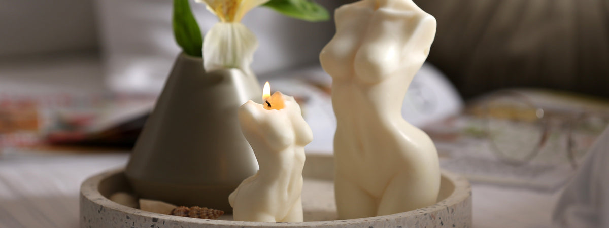 Hand-poured sculptural candles shaped like the female form displayed on a minimalist tray, showcasing luxury handmade candle design and cozy home styling trends for 2026.