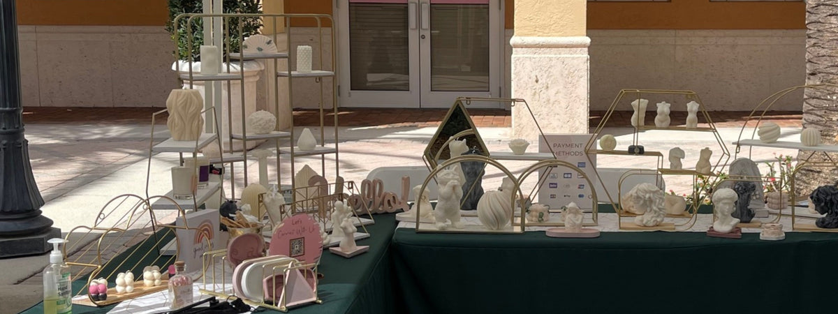 Dahil Bar market display with sculptural candles, gold shelves, and green tablecloths.