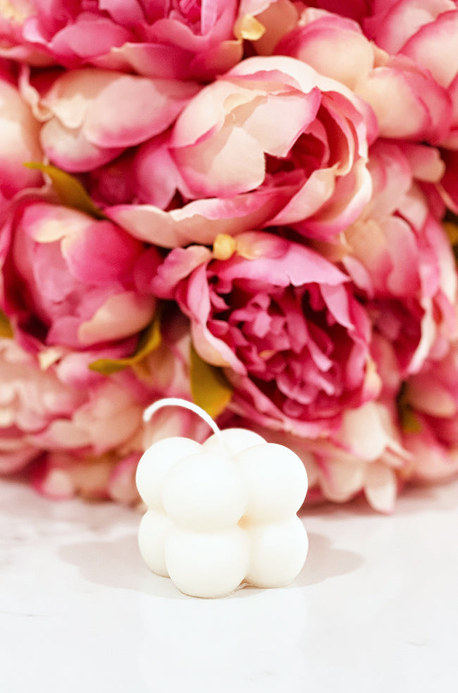 Mini Bubble Candle: White Mini Bubble candle displayed with pink peonies in the background, perfect for minimalist home decor.