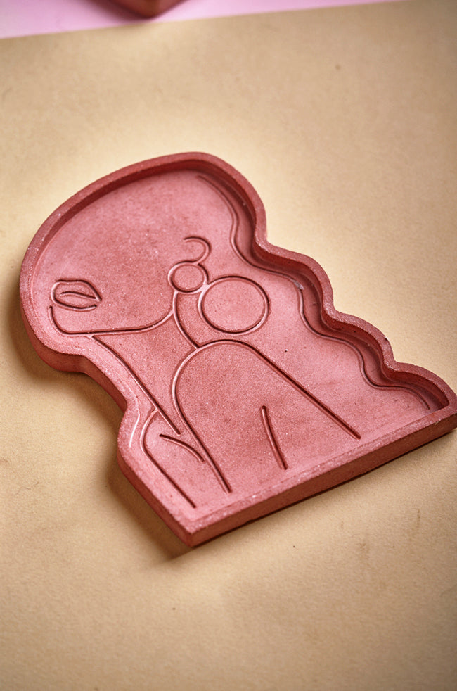 Beauty Candle Tray Terracota: A terracota decorative tray for candles, shaped like a woman's silhouette with minimalist line art details, perfect for holding sculpted or small candles.