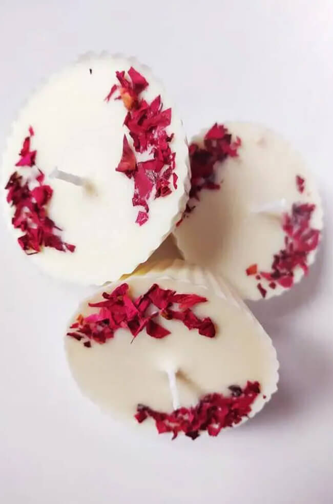 Cup Cake Candle: Top view of three white cupcake-shaped candles decorated with dried red flower petals.