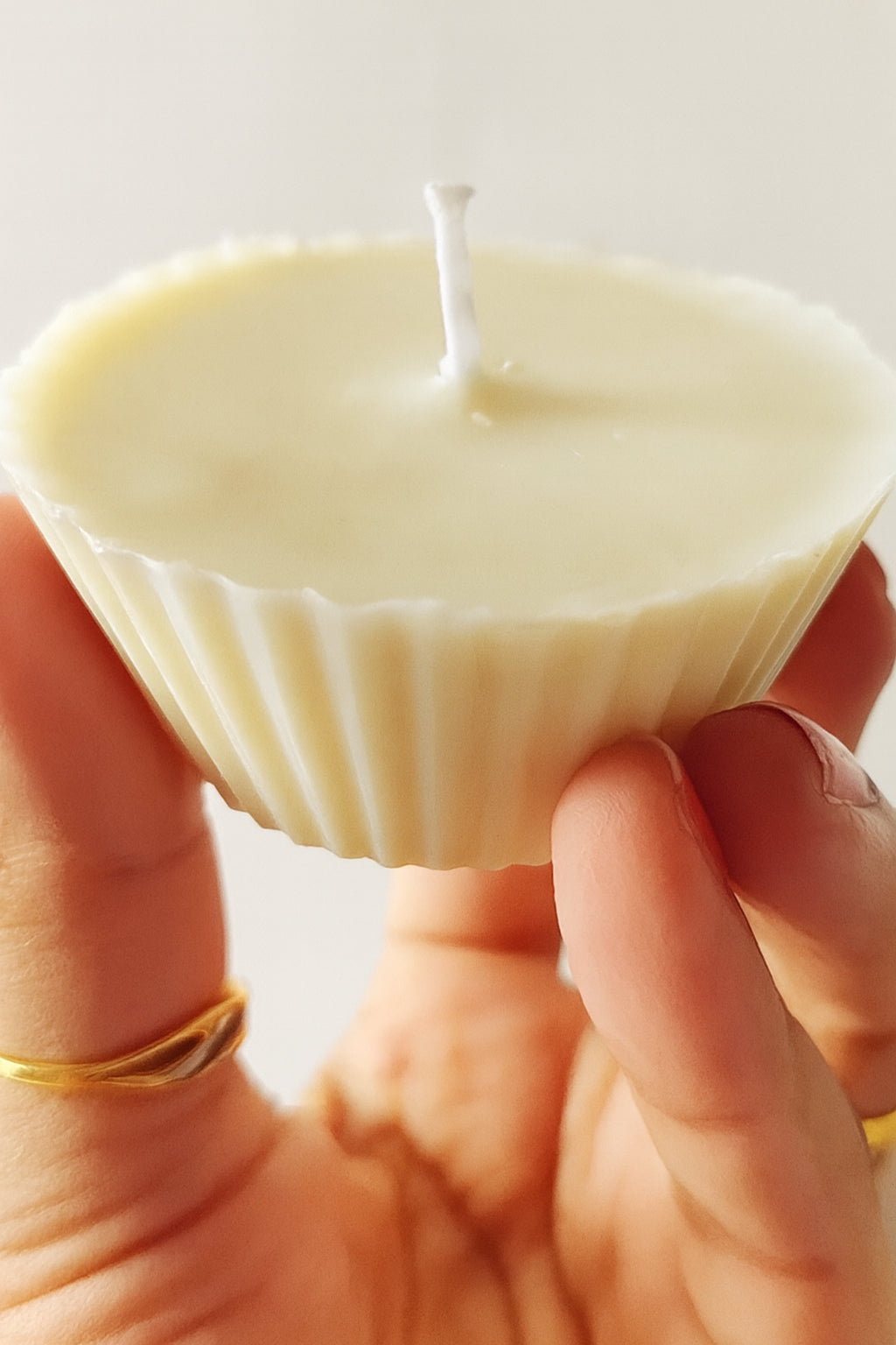 Cup Cake Candle: Hand holding a white cupcake-shaped candle, showcasing its detailed texture and elegant design.