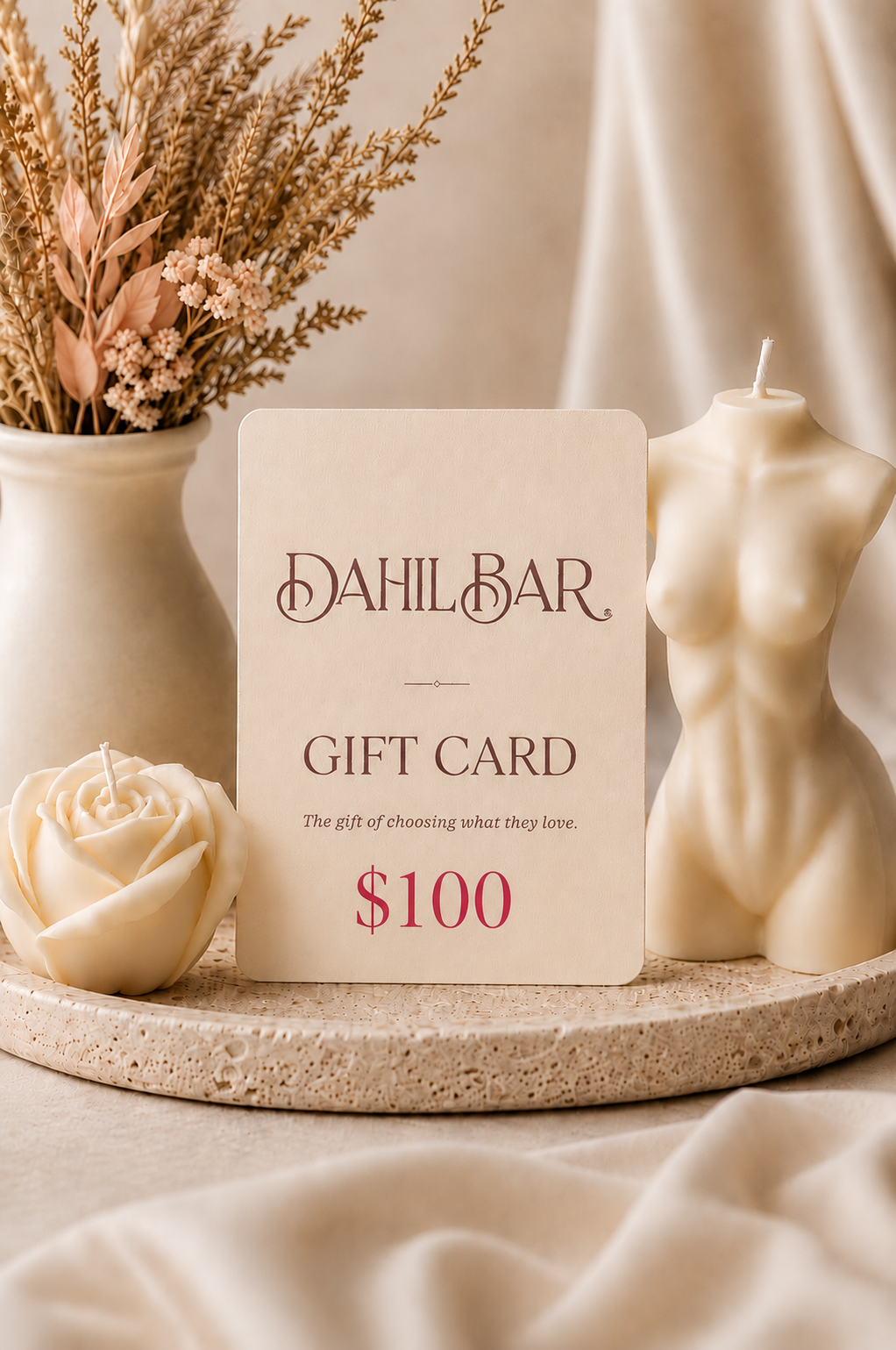 Dahil Bar $100 digital gift card displayed with an ivory rose candle and sculptural body candle in a warm, neutral luxury setting.