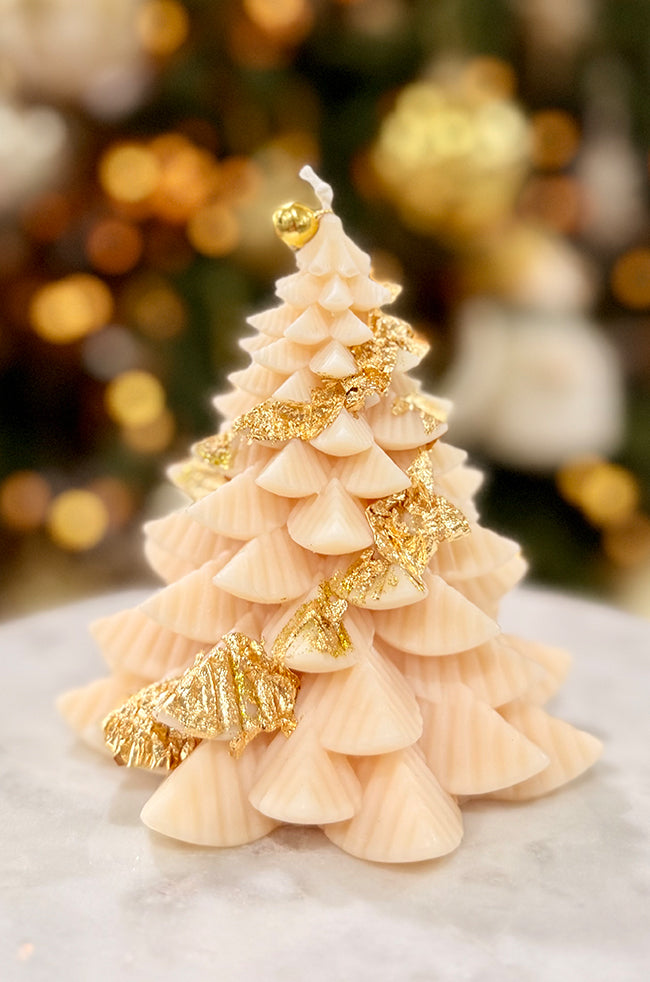 Fiery Tree Large Candle: Handmade large Christmas tree candle featuring an ivory sculpted design, gold leaf detailing, and gold bell topper in warm holiday décor.