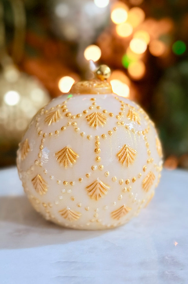 Golden Star Ornament Candle: Golden Star Ornament candle shown on marble surface, glowing under soft lighting, featuring a golden bell and symmetrical hand-painted design.