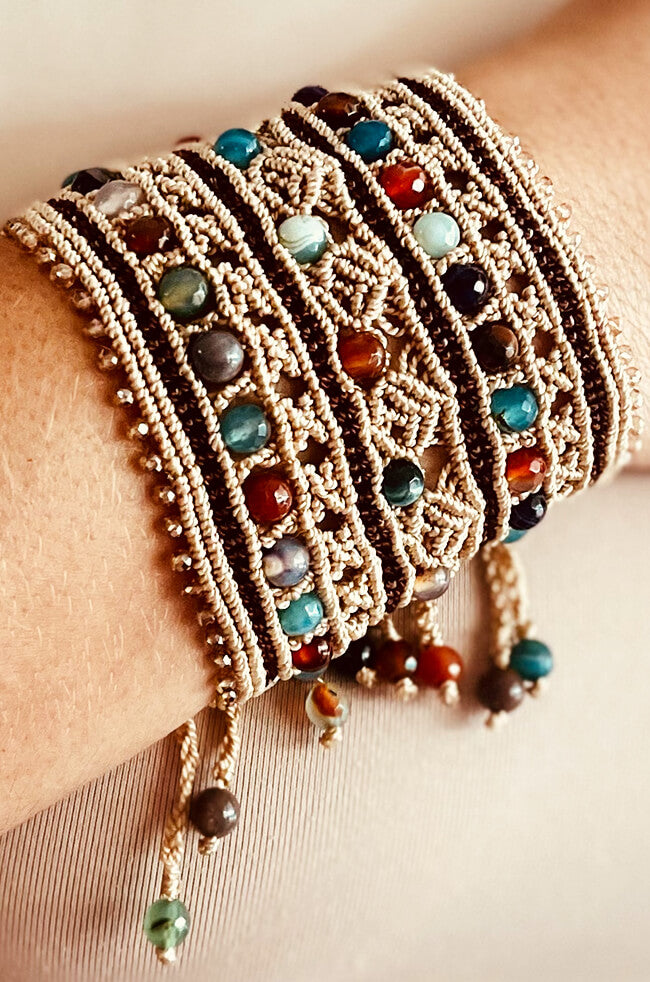 Khaki: A handcrafted bracelet made with intricate beige macrame work, adorned with multicolored round gemstone beads and finished with dangling bead-tipped cords.