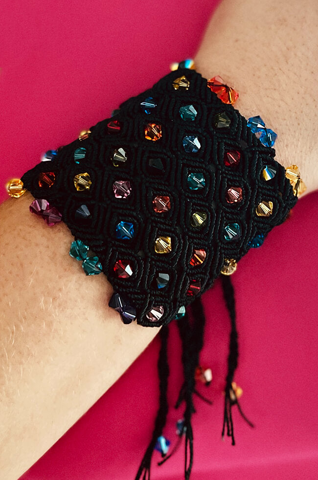 Onyx: A wide black macrame bracelet featuring a diamond-patterned weave, embellished with colorful faceted beads and finished with dangling beaded cords.