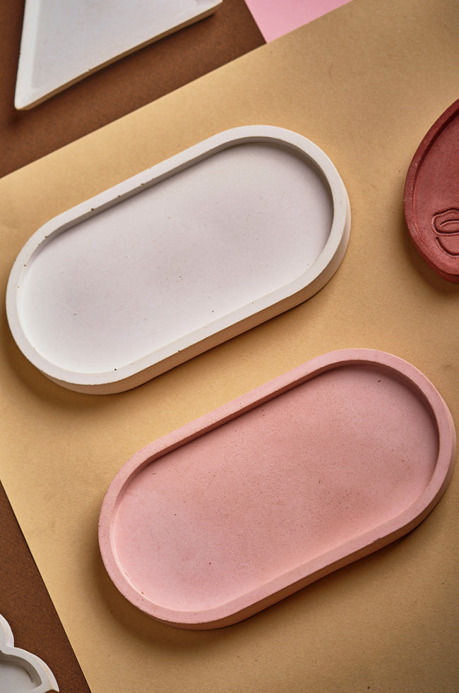 Oval Tray: Flat lay of minimalist oval trays in soft white and blush tones, perfect for displaying sculpted candles or accessories.
