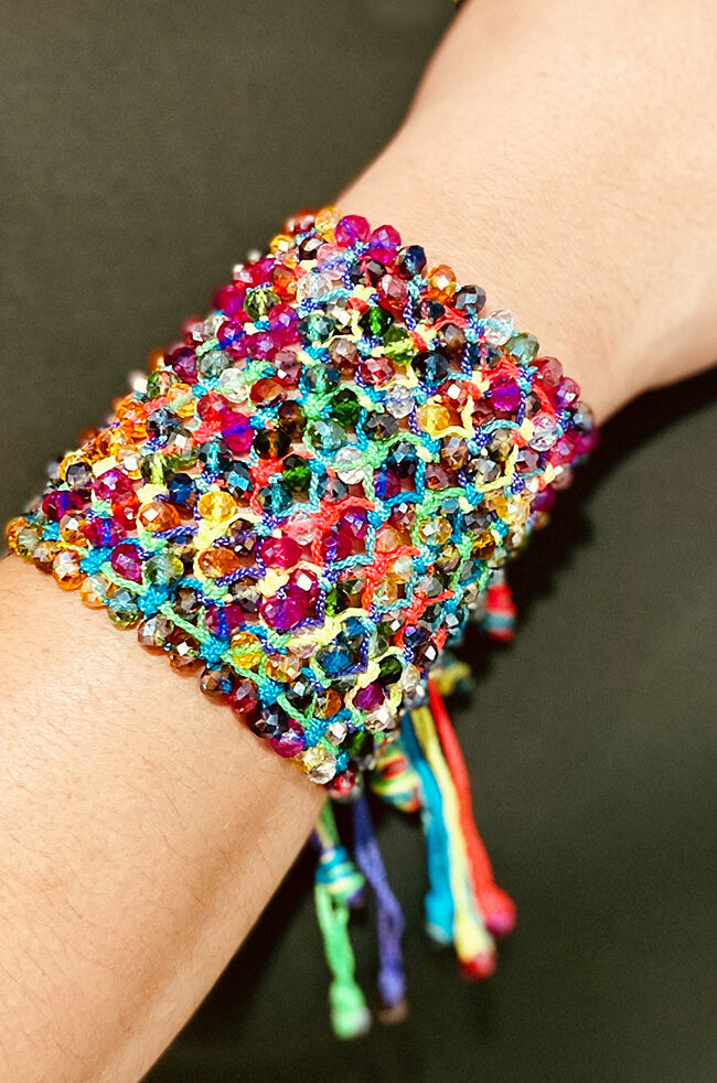 Rainbow: A bold and colorful handmade bracelet adorned with sparkling multicolored beads and vibrant rainbow threads, creating a dazzling, textured cuff with playful hanging ties.