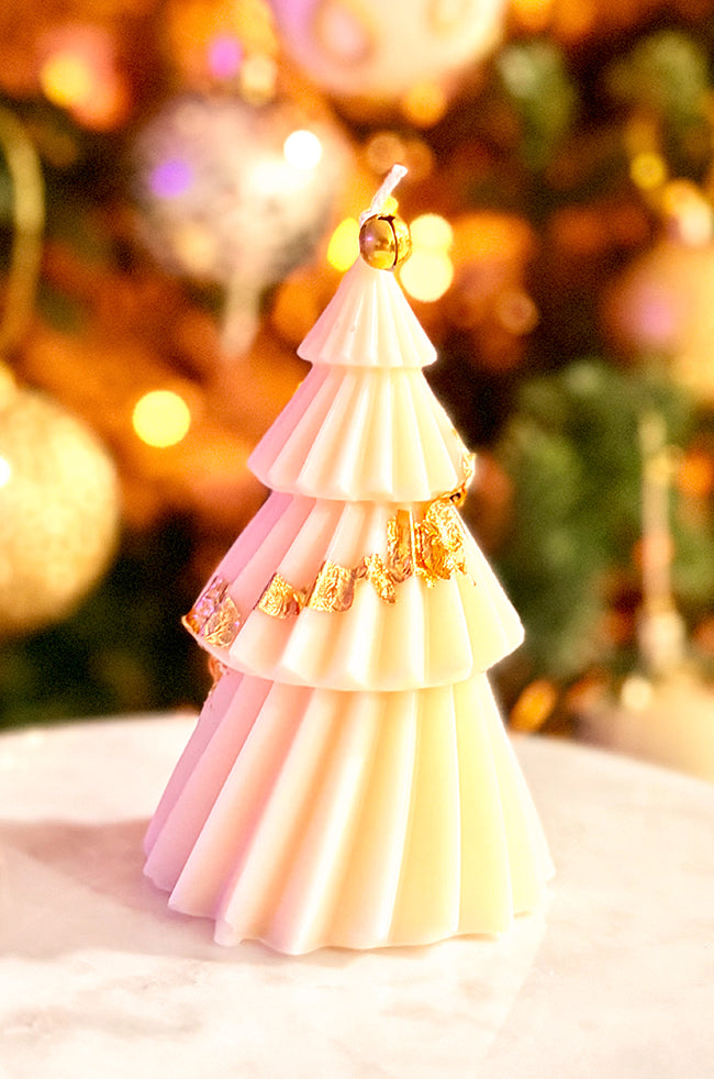 Solstice Tree Large Candle: Modern sculpted Christmas tree candle topped with a gold bell, exuding a warm, minimalist holiday ambiance.
