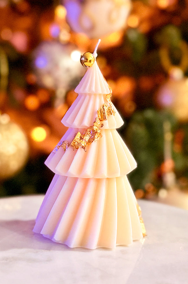 Solstice Tree Large Candle: Handcrafted cream tree candle with tiered folds and subtle holiday lighting, ideal for modern home décor styling.