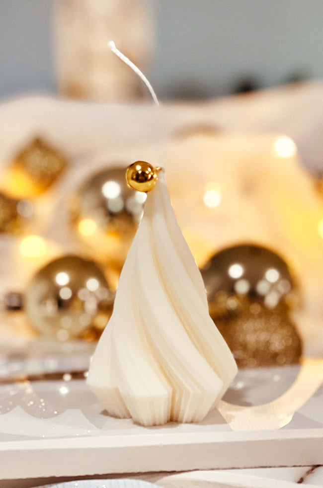Swirling Fire Tree Small Candle: Elegant cream-colored fir-inspired candle with a festive gold bell topper, perfect for luxury holiday home décor.