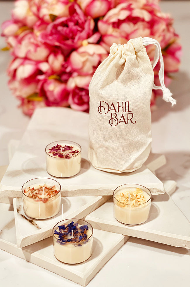 Tea Light Passion: Four cream soy tea light candles topped with dried flowers, displayed with a Dahil Bar cotton muslin bag and pink floral background.