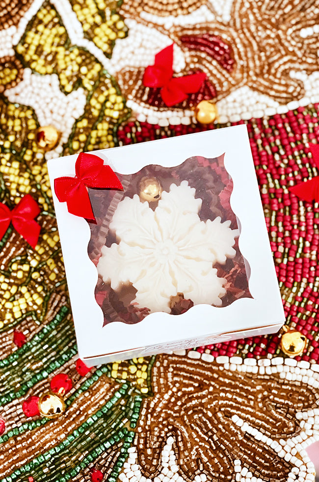 The Christmas Snowflake Candle: Top view of The Christmas Snowflake candle packaged in a white window gift box with red bow.