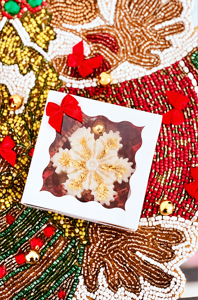 The Christmas Snowflake Candle: The Christmas Snowflake candle with gold flakes and gold bell packaged in a white gift box with red bow.