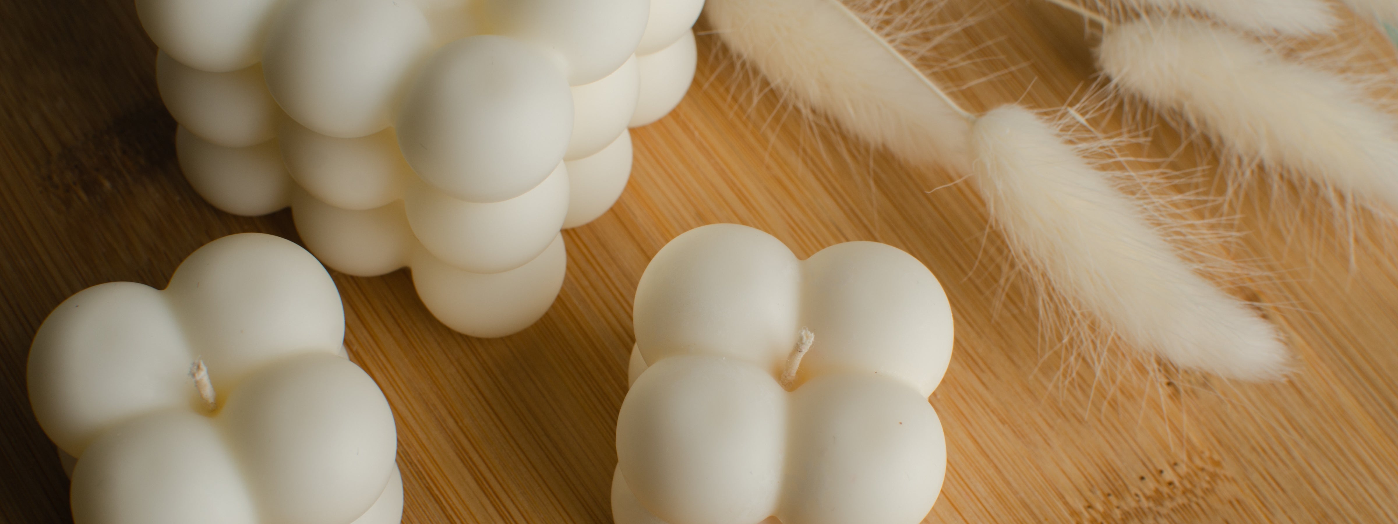 Luxury sculptural bubble candles on a wooden surface with soft neutral tones, styled for modern home decor and candle warmer aesthetic.