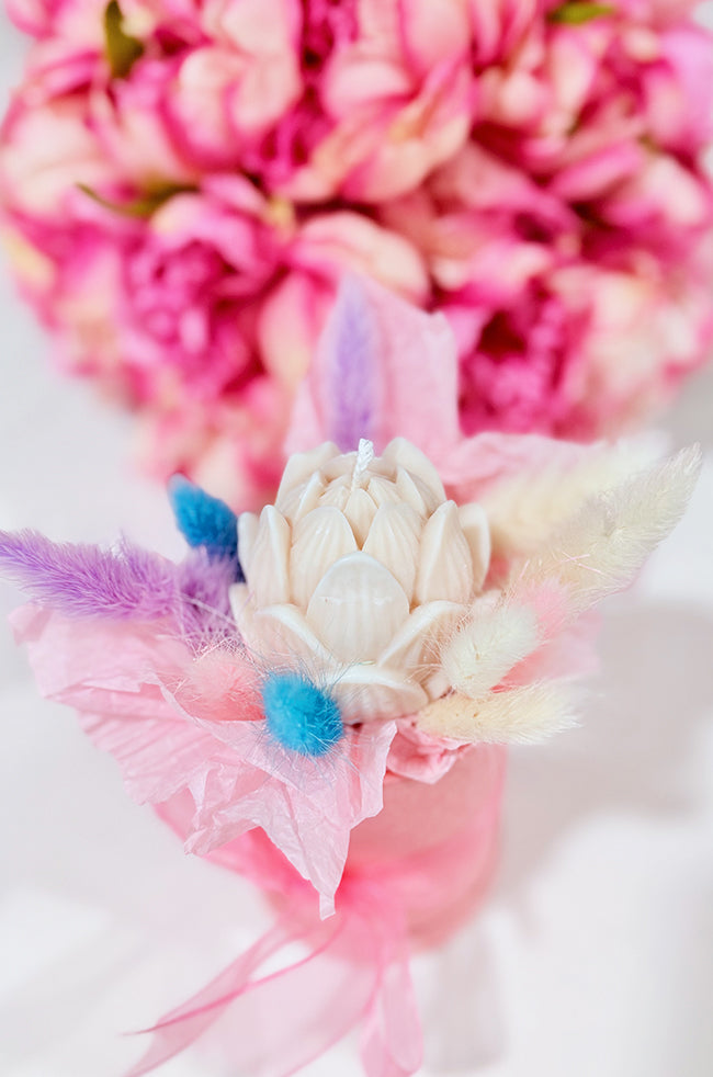 Tulip Glow Candle: Handmade sculptural Tulip Glow candle shaped like a blooming tulip, wrapped with pink and pastel decorative accents, styled with flowers for luxury home décor.