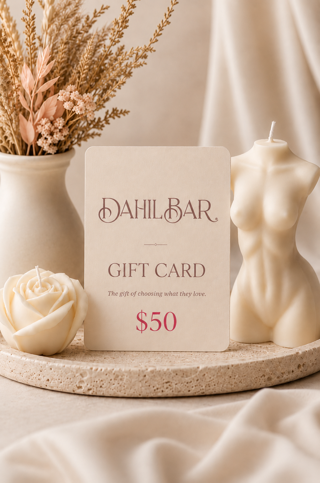 Dahil Bar $50 digital gift card displayed with an ivory rose candle and sculptural body candle in a warm, neutral luxury setting.