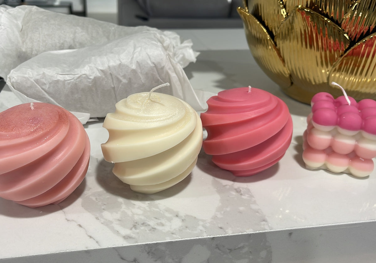 Early Dahil Bar creations featuring pink and ivory Fiery Swirl candles beside a layered pink-and-white Bubble candle.