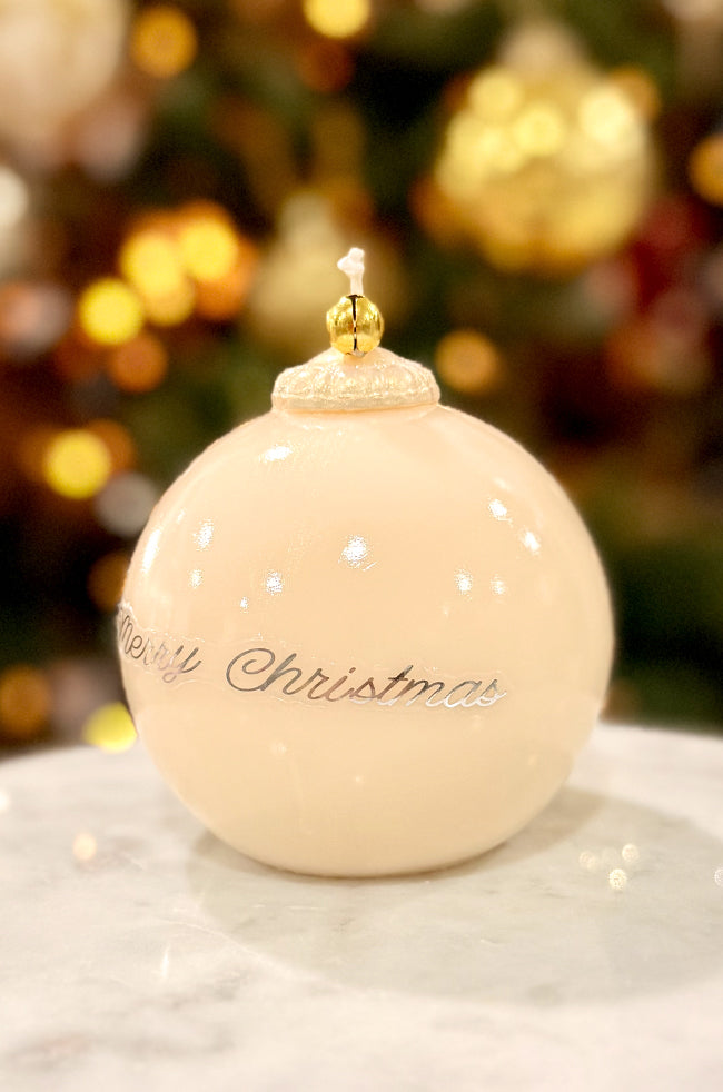 Golden Merry Ornament Candle: Luxury ivory ornament-shaped candle featuring a gold bell topper and elegant “Merry Christmas” text, styled in warm minimalist holiday décor.