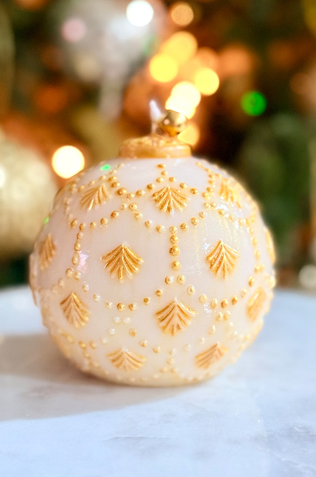 Golden Star Ornament Candle: Detailed view of a sculpted holiday candle inspired by classic ornaments, highlighted with golden motifs and topped with a metallic bell.