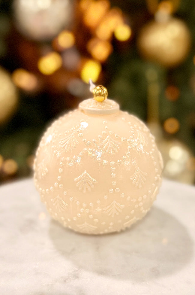 Golden Star Ornament Pear Candle: Close-up of an ivory ornament-style candle featuring embossed leaf motifs and a shiny varnished finish, accented with a gold bell on top, set against a softly blurred golden Christmas backdrop.