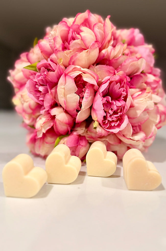 Heart Wax Melts: Four ivory heart-shaped wax melts styled in front of a pink peony bouquet.