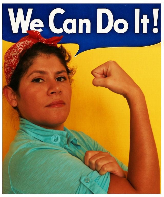 Hilda Rodriguez posing in a Rosie the Riveter–inspired “We Can Do It!” portrait, wearing a red bandana and flexing her arm against a blue and yellow background.