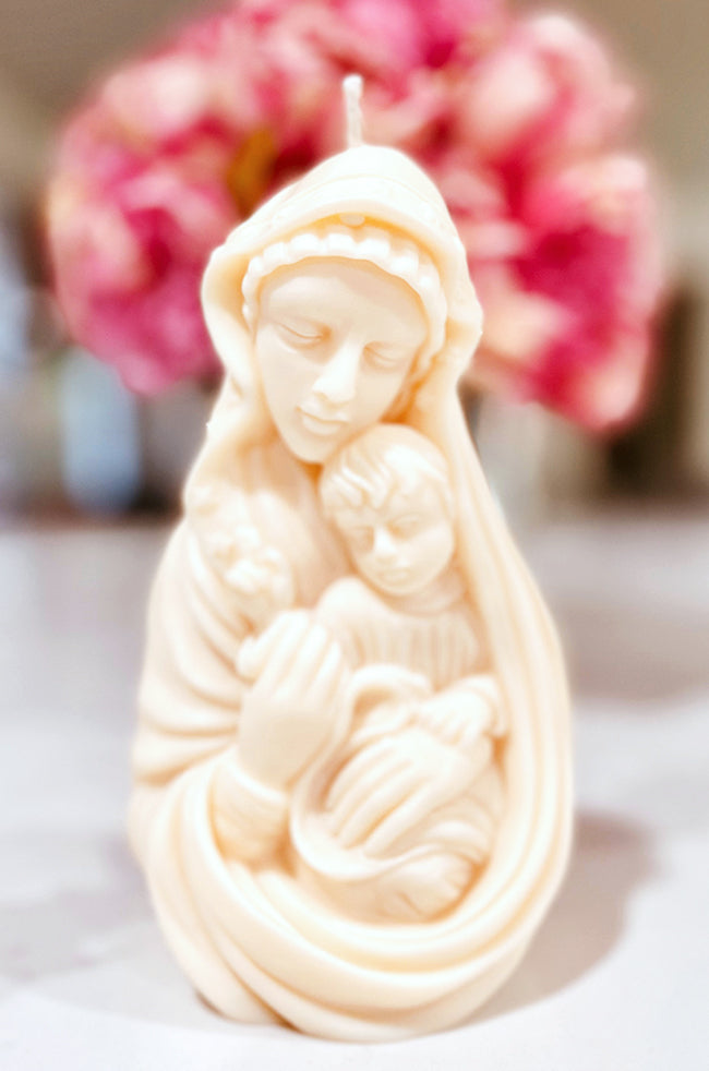 Madonna's Love Candle: Close-up of the Madonna’s Love candle featuring an intricate carving of a mother tenderly holding her child.