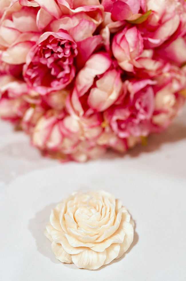 Peony Bliss Candle: Close-up of Peony Bliss flower-shaped candle featuring layered petal details in a neutral ivory tone.