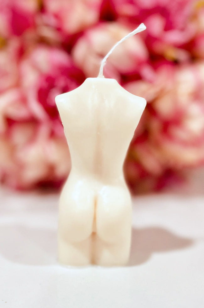 Pregnant Venus Candle: Back view of the ivory Pregnant Venus sculptural body candle with pink flowers.