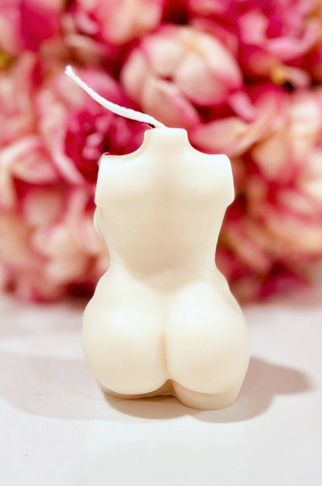 Resilient Warrior Candle: Back view of the ivory Resilient Warrior sculptural body candle with pink floral background.