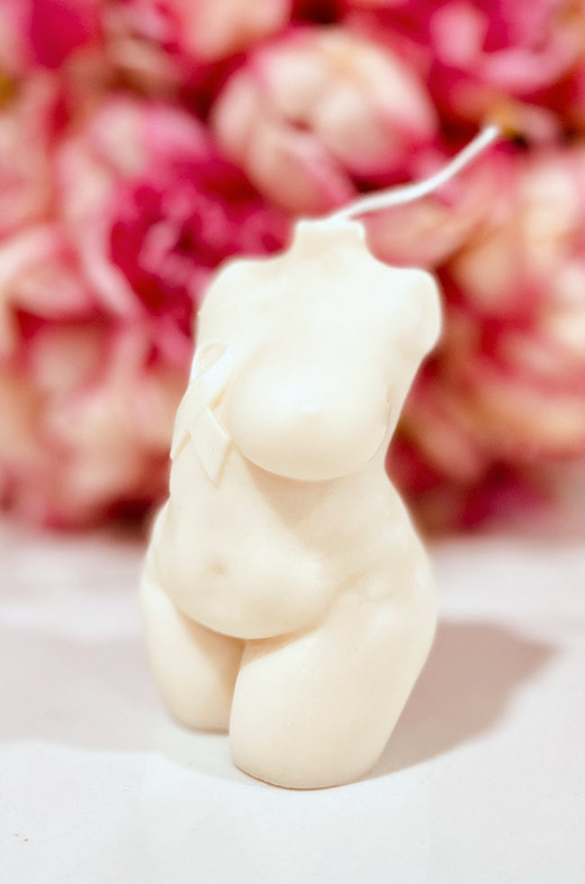Resilient Warrior Candle: Front angled view of the Resilient Warrior candle with awareness ribbon and soft pink flowers.