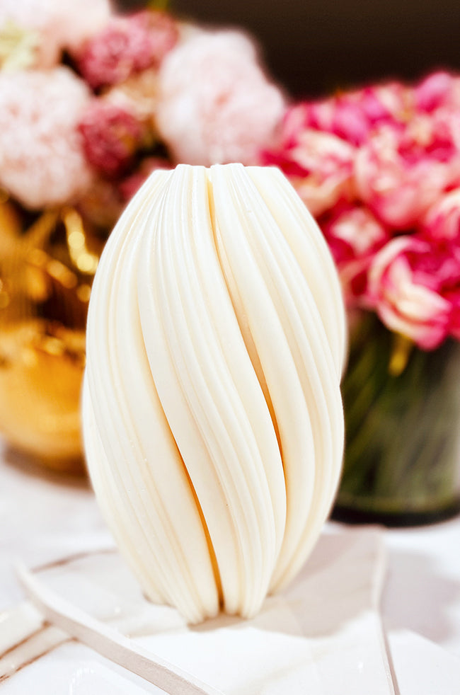 Rising Column Large Candle: Ivory Rising Column Large sculptural candle with twisting ribbed design and floral background.