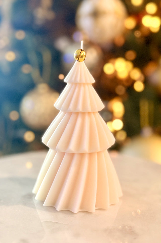 Solstice Tree Large Candle: Hand-poured tree candle with folded tier design, featuring gold foil details and a golden bell accent, styled in a festive setting.