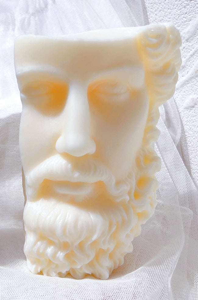 Stoic Candle: Ivory Stoic sculptural candle featuring a detailed classical bearded face, styled against soft white fabric.
