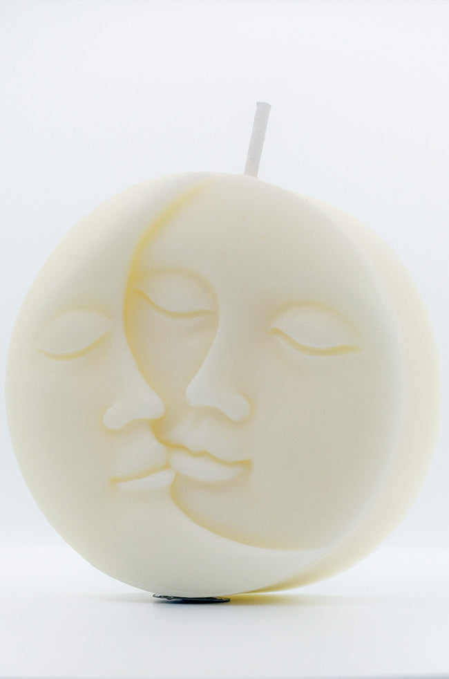 Sun Moon Rising Candle: Front view of the ivory Sun Moon Rising sculptural candle with intertwined sun and moon faces against a clean white background.