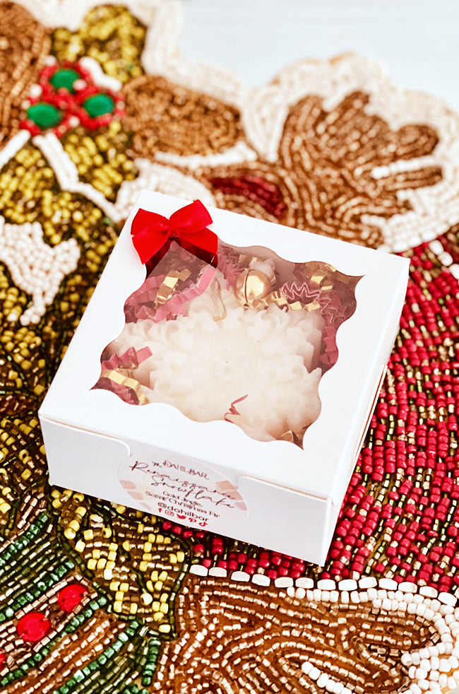 The Renaissance Snowflake Candle: Renaissance Snowflake candle in a white holiday gift box with red bow, clear window, and decorative Christmas packaging.