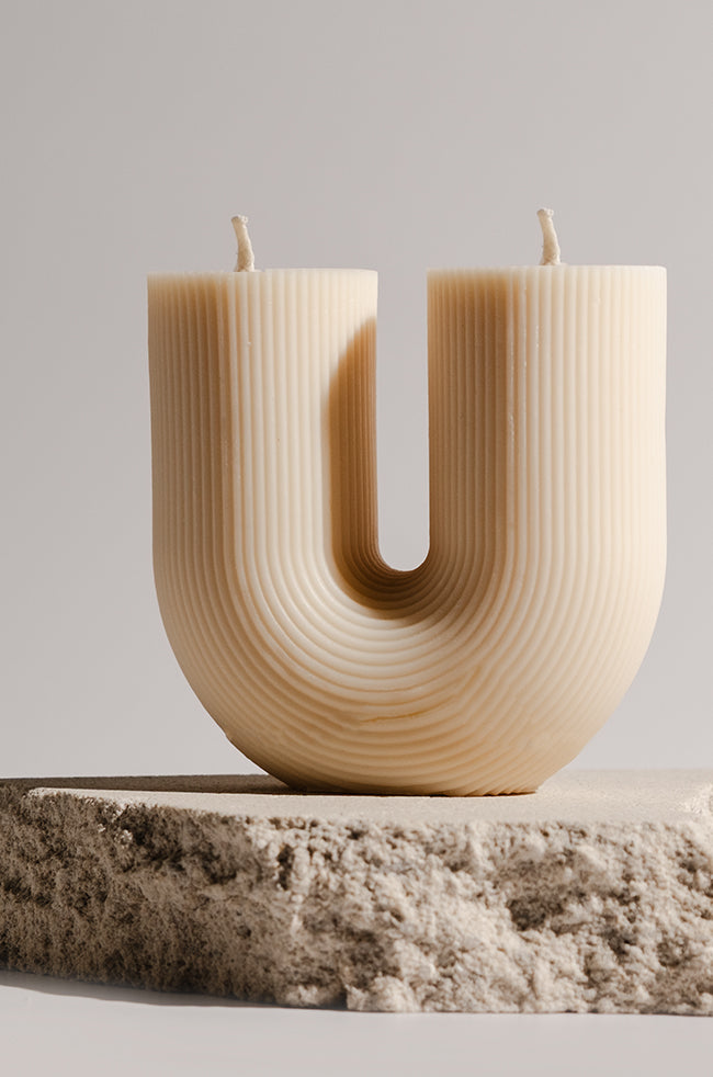 Twin Candle: Handmade Twin Candle featuring a modern U-shaped sculptural design with two wicks, crafted from natural wax and displayed on a stone base — perfect for minimalist and luxury home décor.